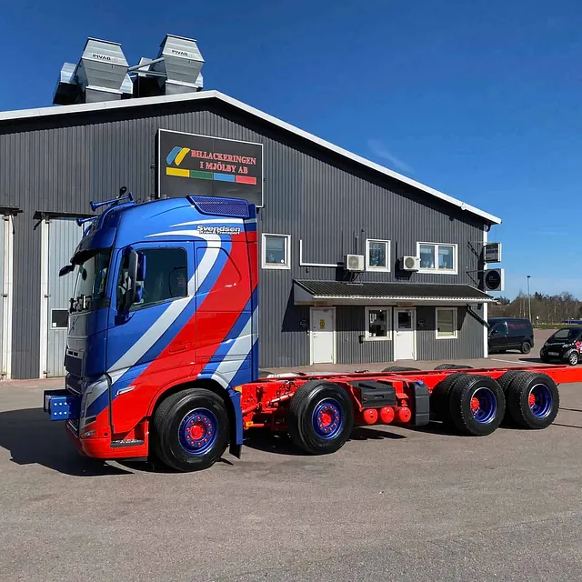 Svendsen trekkvogn uten henger parkert foran grå industribygning i klart vær.